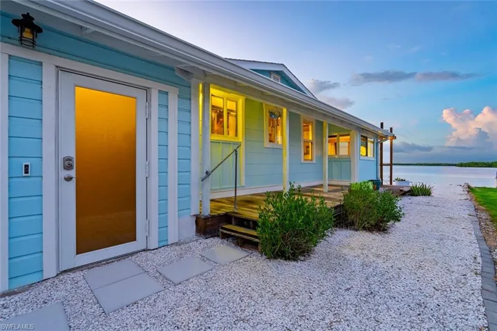 Doorway to property with a porch and a water view