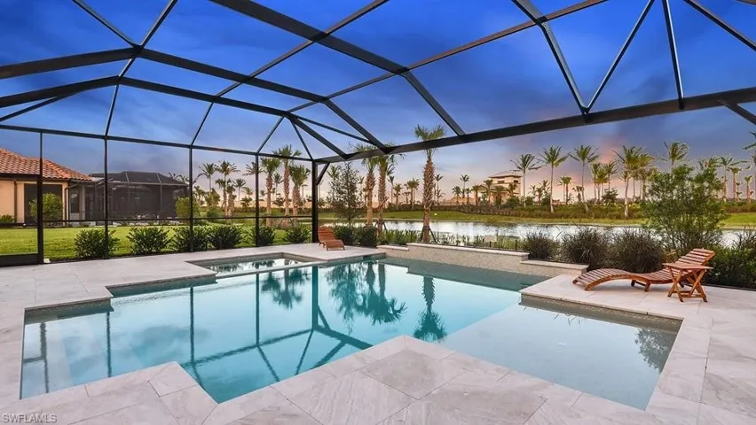 Pool featuring a water view, a patio area, an in ground hot tub, and glass enclosure