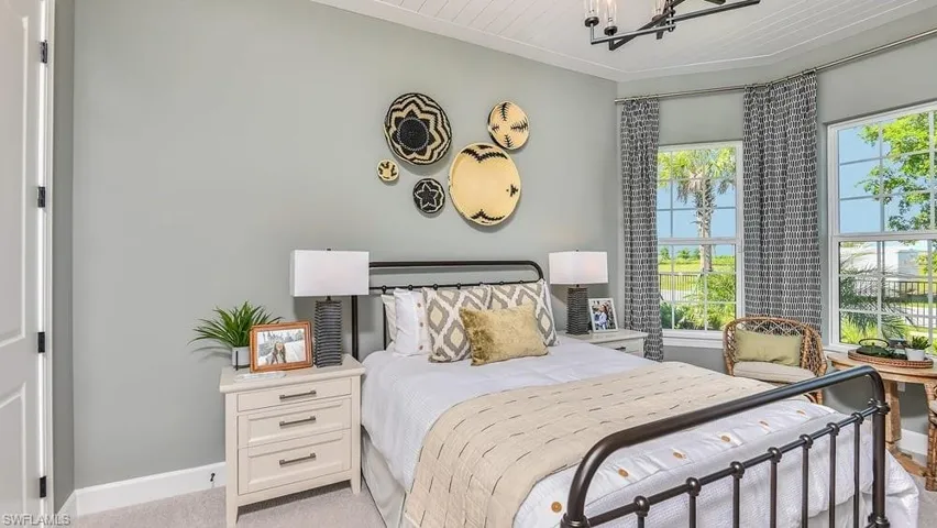 Bedroom featuring baseboards, a notable chandelier, light carpet, and crown molding