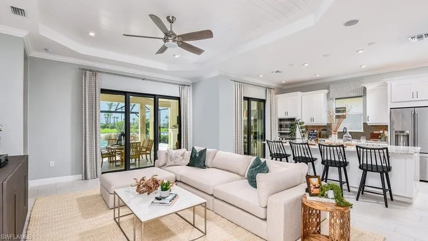 Living room featuring recessed lighting, visible vents, a tray ceiling, and ceiling fan