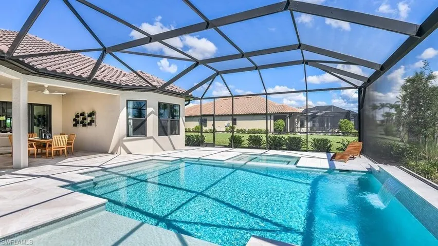 View of swimming pool featuring a patio, outdoor dining area, ceiling fan, and a pool with connected hot tub