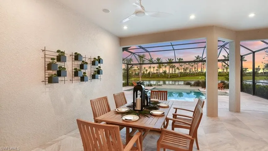 Dining room featuring recessed lighting, a water view, a ceiling fan, and a textured wall