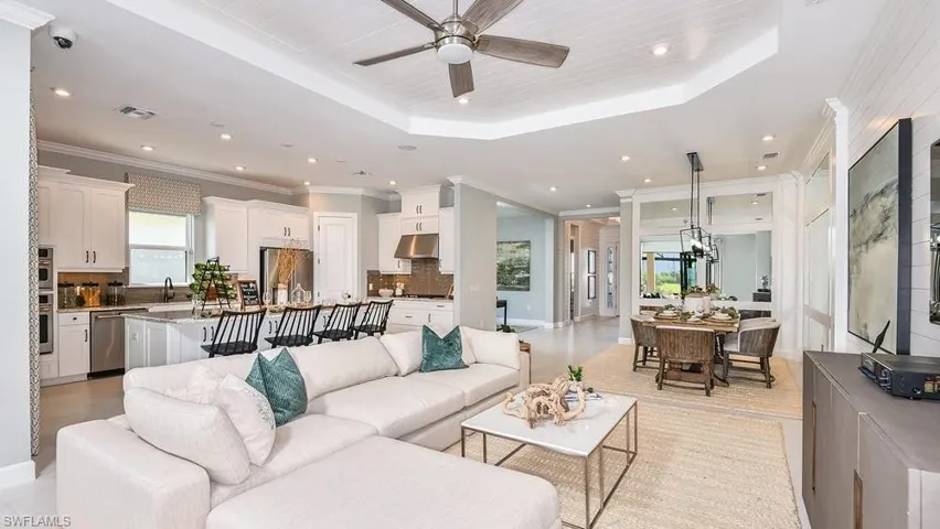Living room with visible vents, recessed lighting, crown molding, a ceiling fan, and a tray ceiling