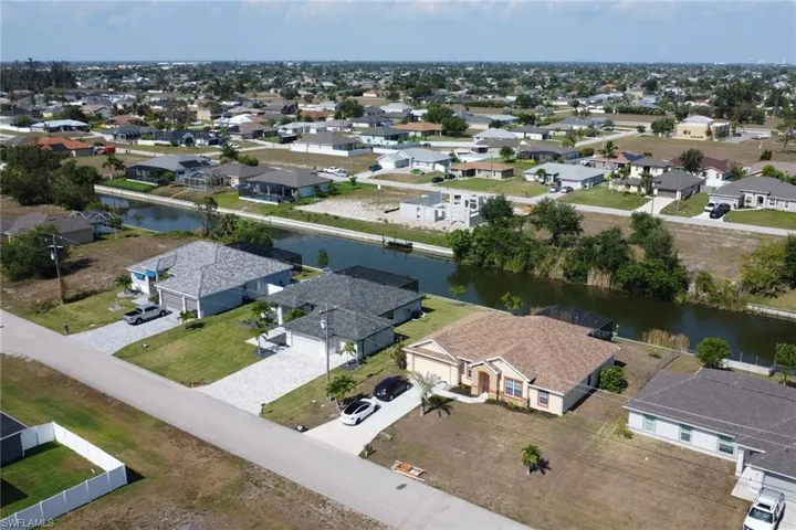 Aerial perspective of suburban area featuring a nearby body of water