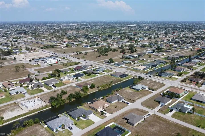 Aerial view of property's location featuring a large body of water and nearby suburban area
