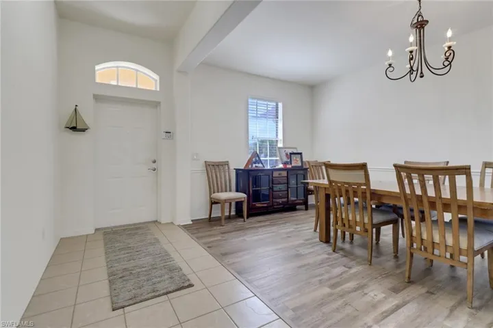 Tiled dining room with healthy amount of natural light and a chandelier