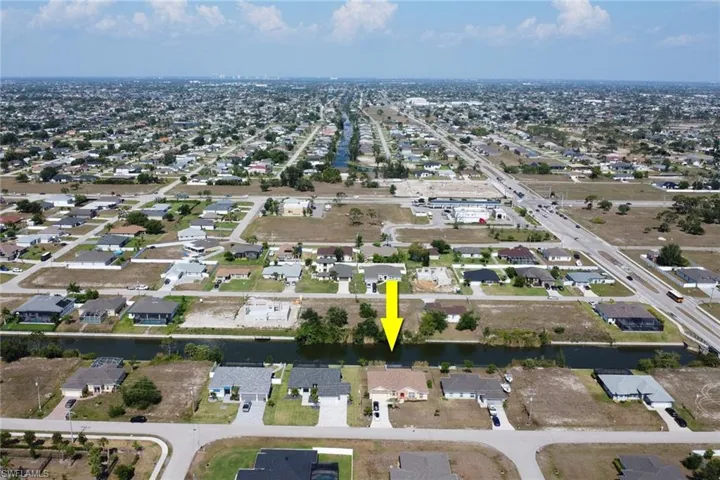 Aerial view of property and surrounding area with nearby suburban area