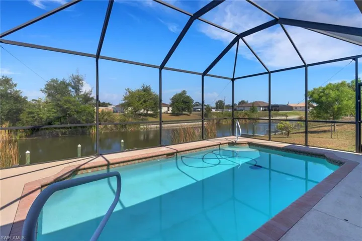 Outdoor pool with a water view, a lanai, and a patio area