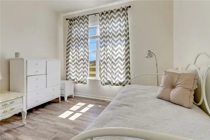Bedroom featuring wood finished floors and baseboards