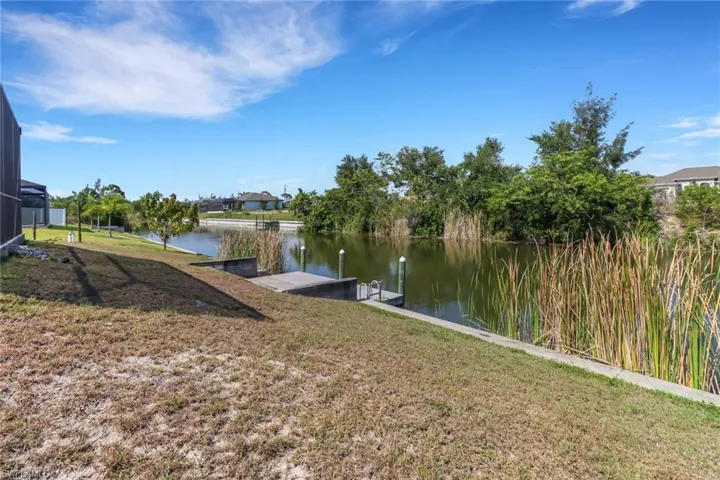 Dock with a water view and a lawn