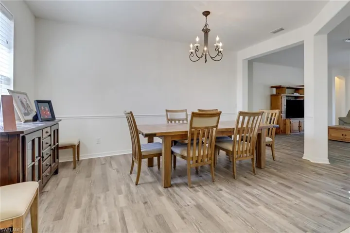 Dining space with a chandelier, light wood-style flooring, and arched walkways