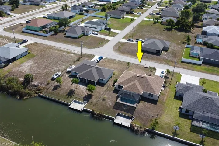Aerial view of property and surrounding area with nearby suburban area and a large body of water
