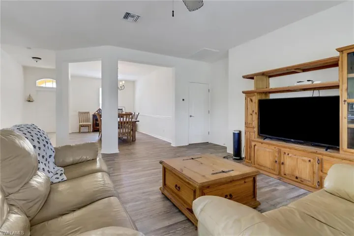 Living room featuring light wood-type flooring and a chandelier