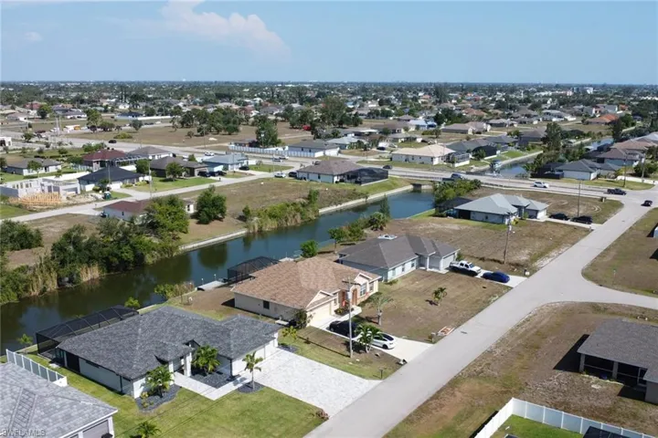Aerial perspective of suburban area featuring a nearby body of water