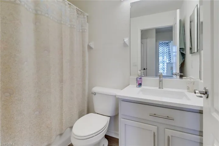 Full bathroom with vanity and curtained shower