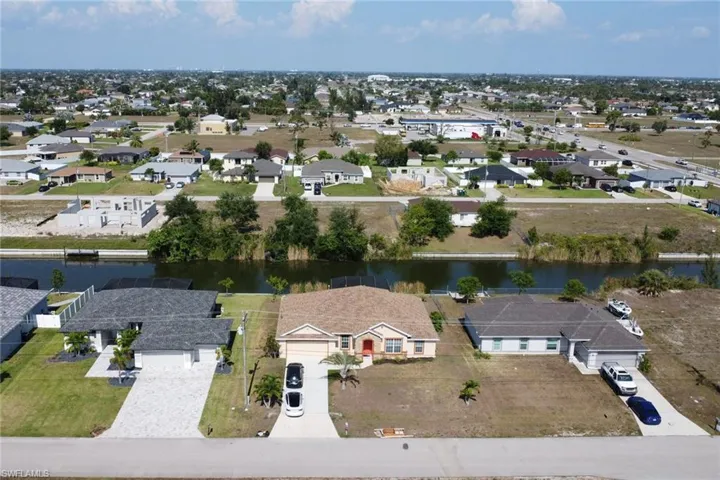 Aerial view of residential area featuring a nearby body of water