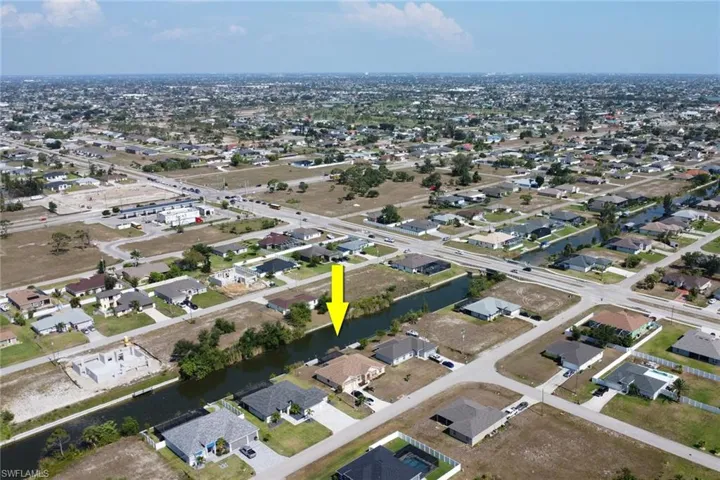 Aerial view of property's location with a large body of water and nearby suburban area