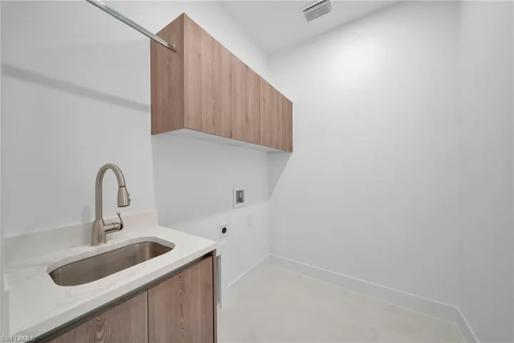 Laundry area with electric dryer hookup, washer hookup, and cabinet space