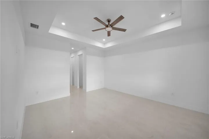 Spare room featuring a ceiling fan, recessed lighting, and a tray ceiling