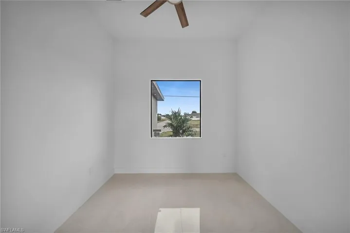 Spare room featuring ceiling fan and baseboards