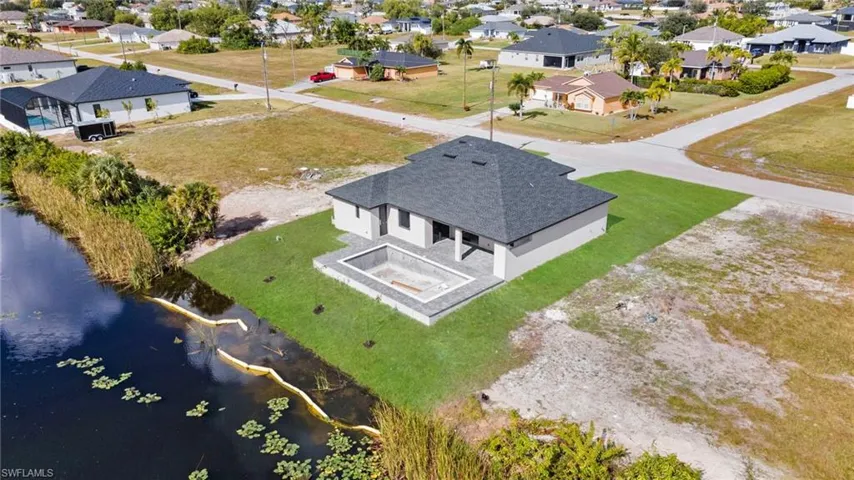 Aerial view of residential area featuring a nearby body of water