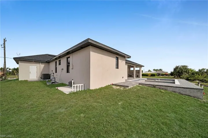 Rear view of property with a patio, stucco siding, and a yard