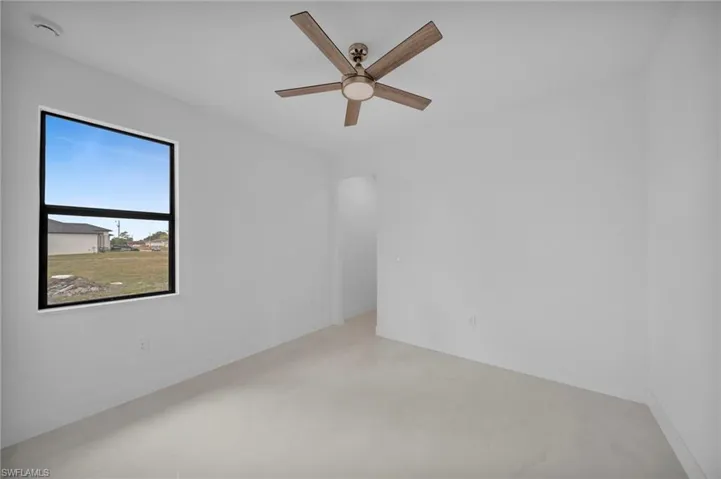 Unfurnished room featuring a ceiling fan and baseboards