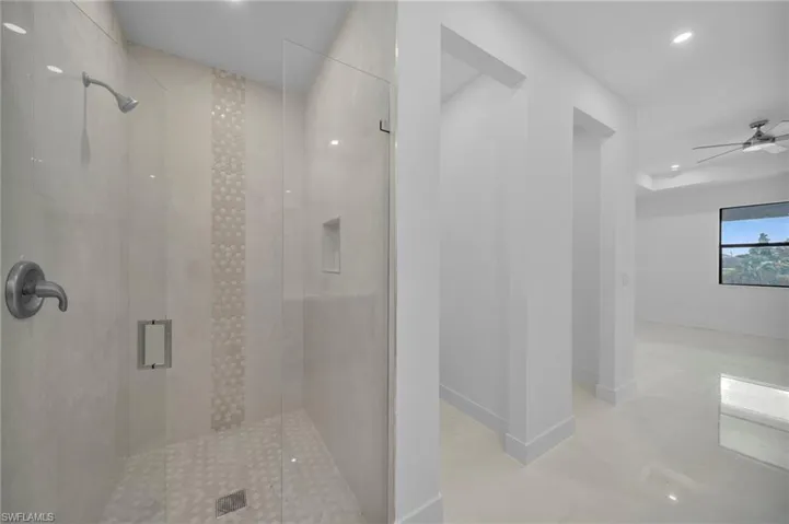 Bathroom with a stall shower, ceiling fan, and recessed lighting