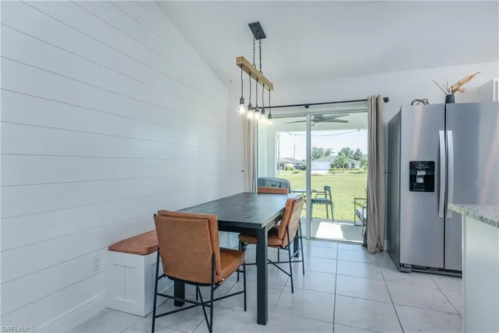 Dining room with light tile floors and vaulted ceiling