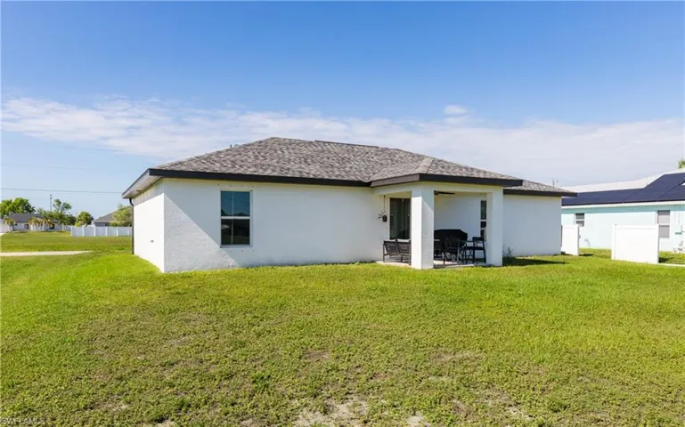 Back of house with a patio and a yard