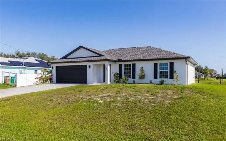 Ranch-style home with a garage, and a front lawn