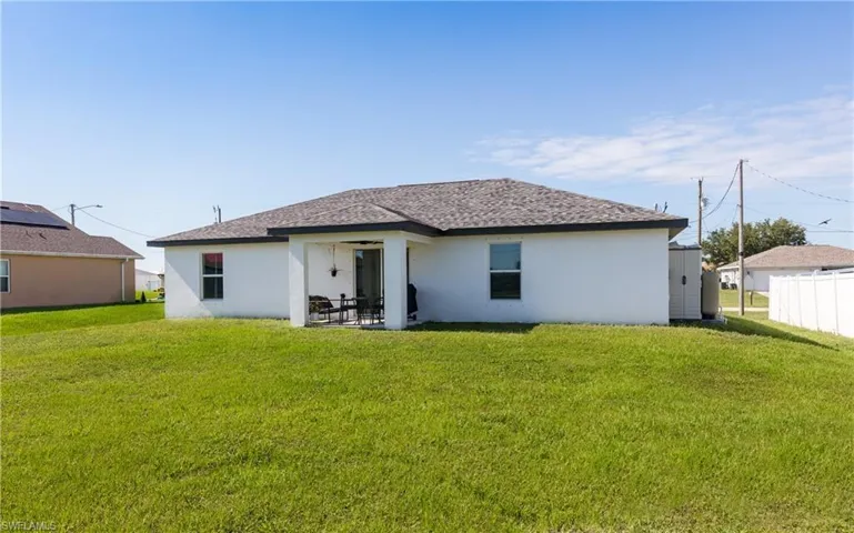 Back of house with a patio area and a yard