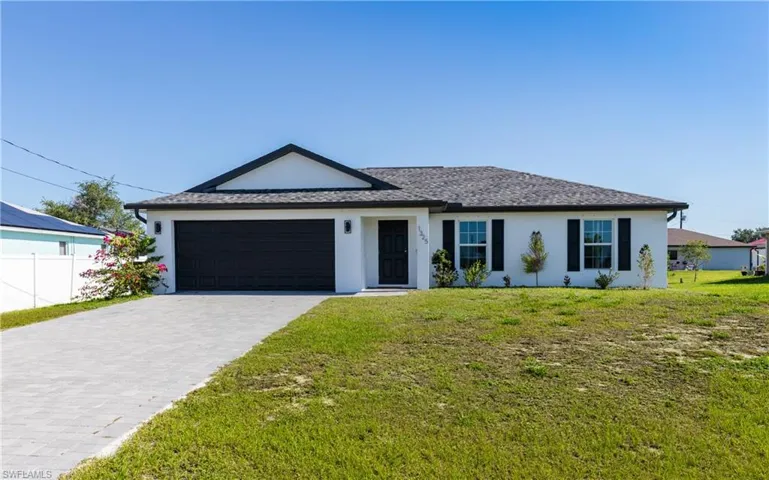 Ranch-style home with a front lawn and a garage