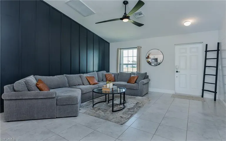 Tiled living room featuring ceiling fan