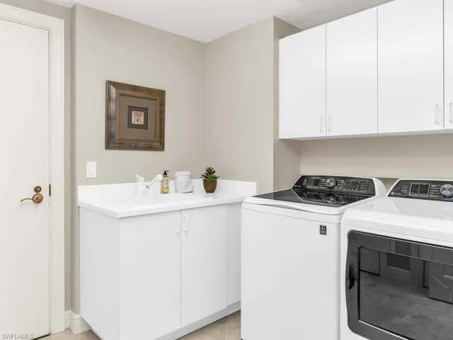 Washroom with cabinets, sink, and washer and dryer