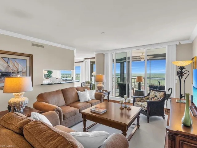 Living room with ornamental molding, floor to ceiling windows, and a wealth of natural light