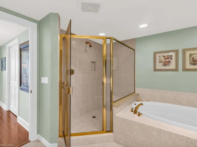 Bathroom with hardwood / wood-style flooring and separate shower and tub