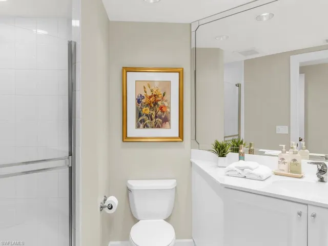Bathroom featuring vanity, an enclosed shower, and toilet