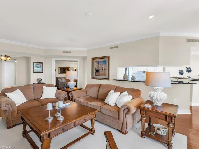 Living room with ornamental molding and light hardwood / wood-style floors