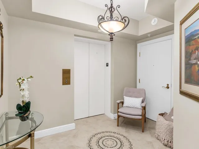 Living area featuring elevator and light tile patterned floors