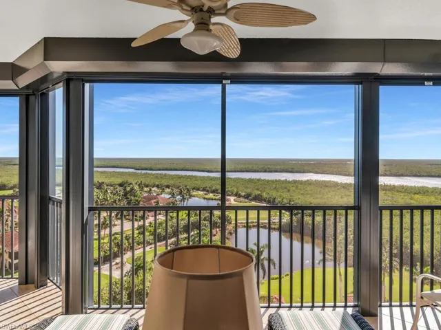 Unfurnished sunroom with ceiling fan, a healthy amount of sunlight, and a water view