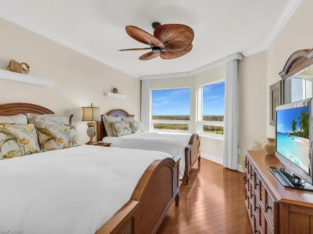 Bedroom with ceiling fan, ornamental molding, and dark hardwood / wood-style floors