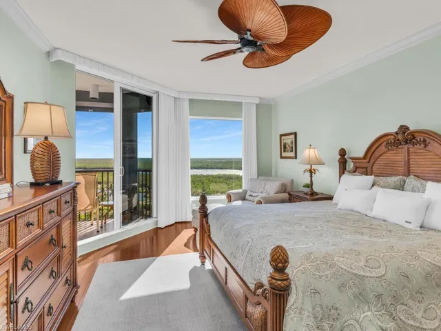 Bedroom featuring crown molding, access to outside, wood-type flooring, and a wall of windows