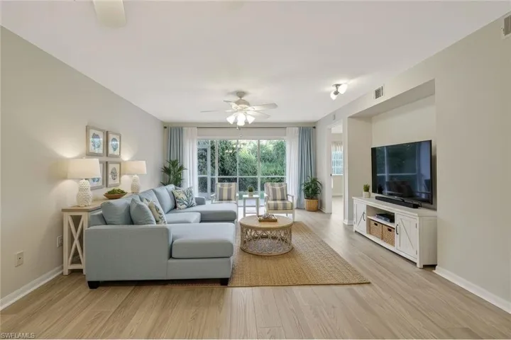 Living room with light wood-type flooring and a ceiling fan