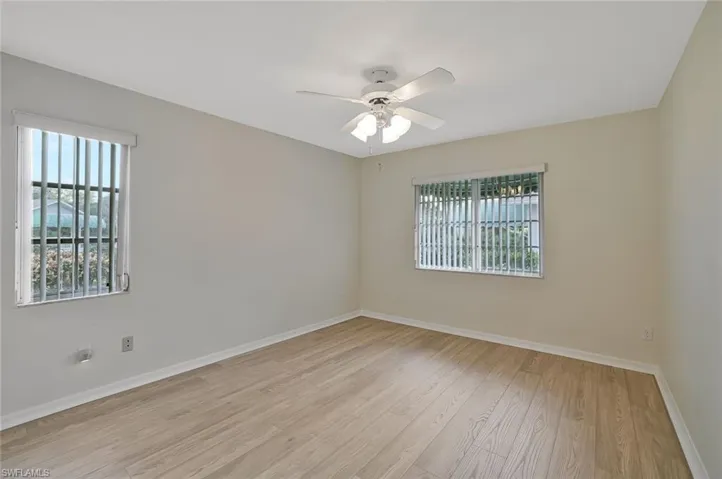 Empty room with light wood-style floors and a ceiling fan