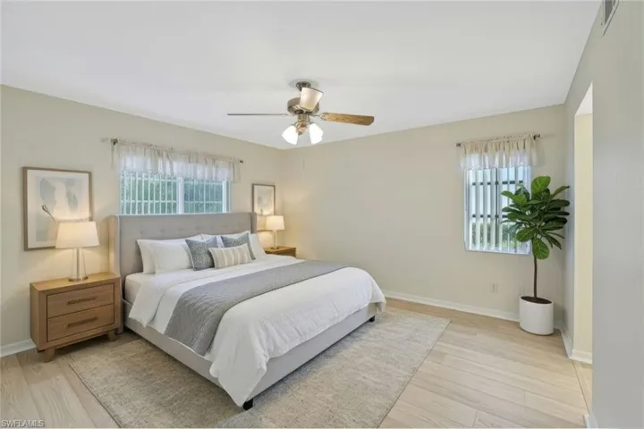 Bedroom featuring multiple windows, light wood-style flooring, and ceiling fan