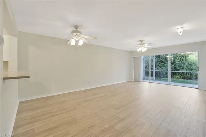 Unfurnished living room featuring light wood-type flooring and ceiling fan