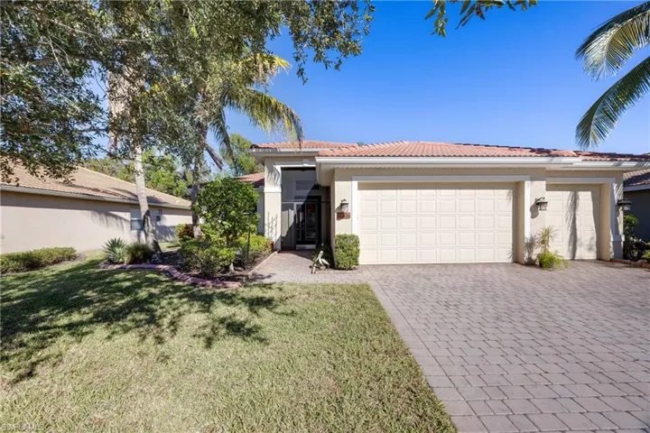 View of front facade featuring a front lawn and a garage