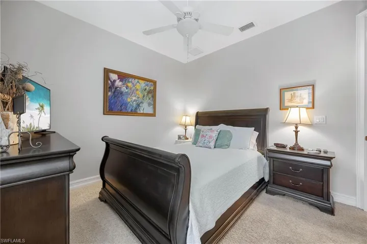 Carpeted bedroom featuring ceiling fan
