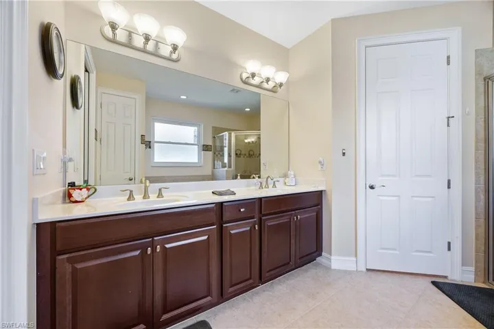 Bathroom featuring tile patterned flooring, vanity, and a shower with shower door